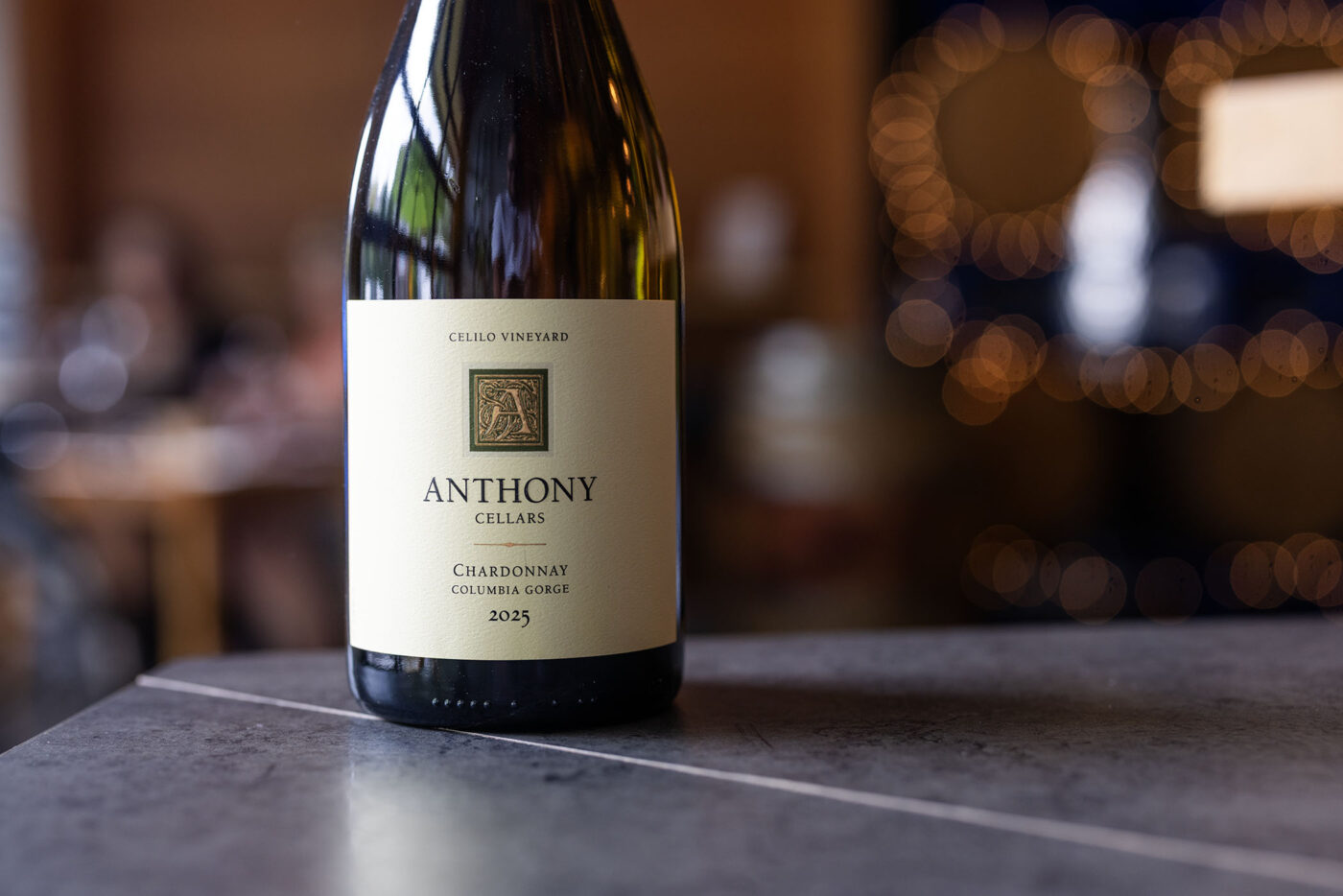 Depict image accurately for accessibility. A bottle of Lobo Hills Chardonnay wine on a table with blurred background.